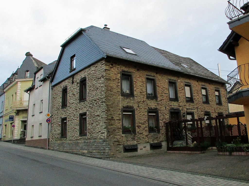 Koblenzerstraße in Kaisersesch: links hinter dem renovierten Bruchsteinhaus das frühere Synagogengebäude bzw. jüdische Bethaus (2015).
