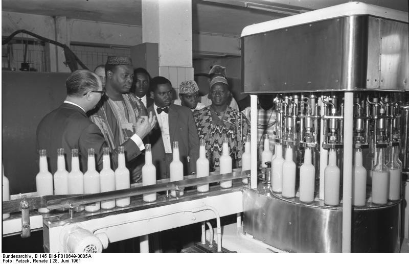 Historische Aufnahme von 1961: Eine Parlaments-Delegation aus der Republik Niger bei der Besichtigung der Firma "Verpoorten" in Bonn, im Bildvordergrund eine Flaschen-Abfüllanlage.