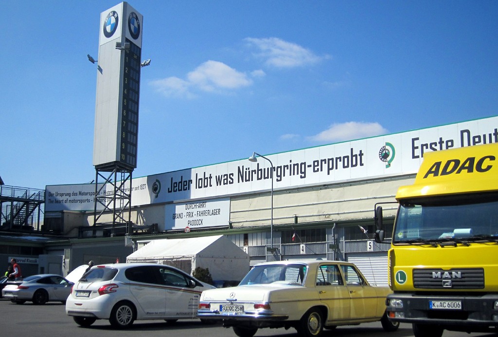 Innenbereich des historischen Fahrerlagers und ein moderner Anzeigeturm mit BMW-Werbung am Nürburgring (2013).
