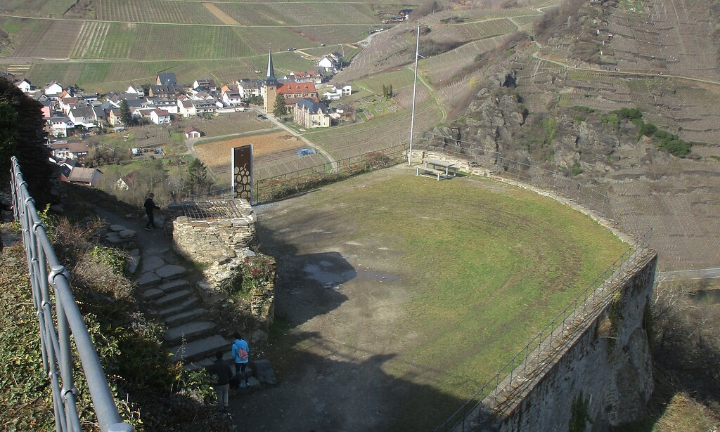 Blick über den Zwinger unterhalb der früheren Hochburg der Burgruine Saffenburg hinunter auf den Ort Mayschoß und die dortige Pfarrkirche St. Nikolaus und St. Rochus (2021).