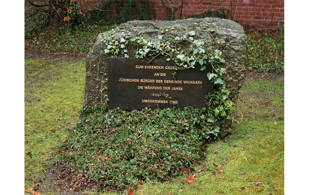 Der Gedenkstein  seiner Inschrift nach vermutlich von der Kommune errichtet  auf dem schmalen Zugangsweg zum eigentlichen Gräberfeld des Judenfriedhofs Roßweide in Wickrath (2015).