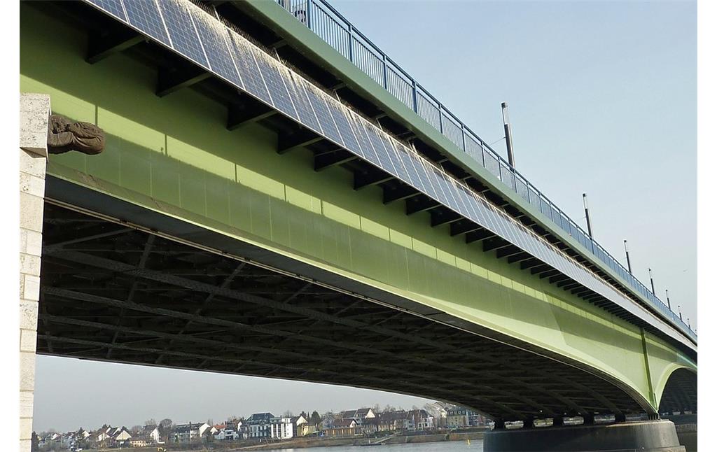 Die Kennedybrücke in Bonn mit dem "Brückenmännchen" und der Solaranlage (2012). Das "Brückenmännchen" befand sich ursprünglich an der Vorgängerbrücke "Alte Rheinbrücke" und streckte von dieser aus seinen nackten Hintern zur Beueler Rheinseite auf der "schäl Sick" hin aus.