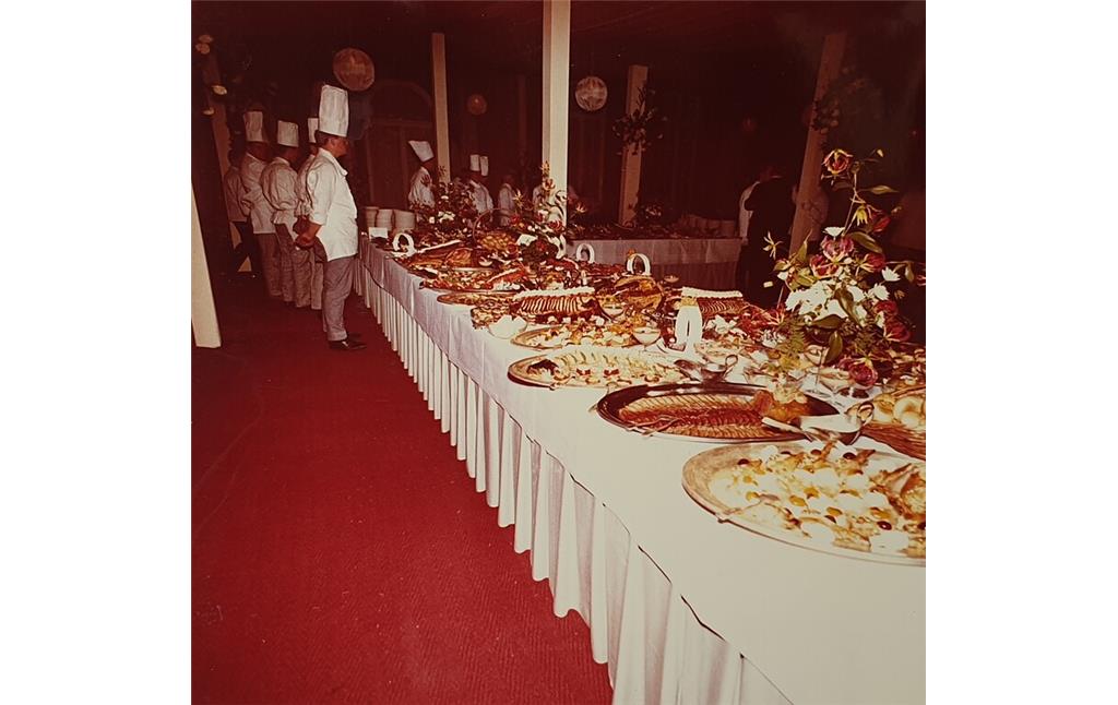 Festlich angerichtetes Menü anlässlich einer Feier in der Bonner Beethovenhalle, im Hintergrund stehen die Köche und erwarten die Eröffnung (1960er Jahre).