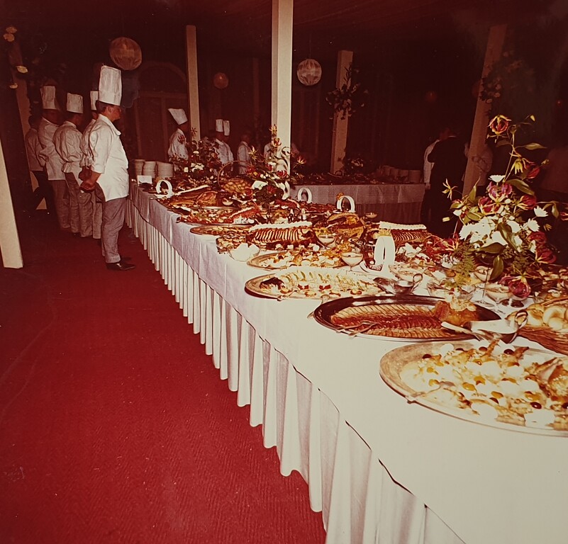 Festlich angerichtetes Menü anlässlich einer Feier in der Bonner Beethovenhalle, im Hintergrund stehen die Köche und erwarten die Eröffnung (1960er Jahre).