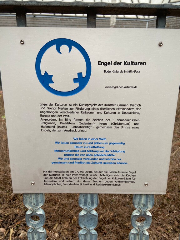 Infoschild der Kunstinstallation "Engel der Kulturen" des Künstlerpaares Carmen Dietrich und Gregor Merten auf dem Alfred-Moritz-Platz in Köln-Porz (2023).