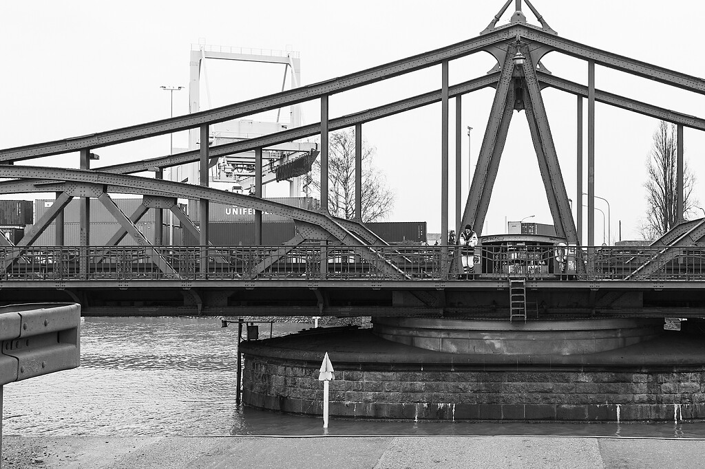 Die 1905 erbaute Jugendstil-Drehbrücke im Rheinhafen Krefeld (2018). Im Bild der Mittelpfeiler der Brücke mit dem Antrieb des Hub- und Drehwerkes, im Hintergrund das Containerterminal.
