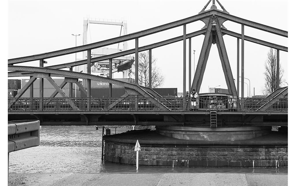 Die 1905 erbaute Jugendstil-Drehbrücke im Rheinhafen Krefeld (2018). Im Bild der Mittelpfeiler der Brücke mit dem Antrieb des Hub- und Drehwerkes, im Hintergrund das Containerterminal.
