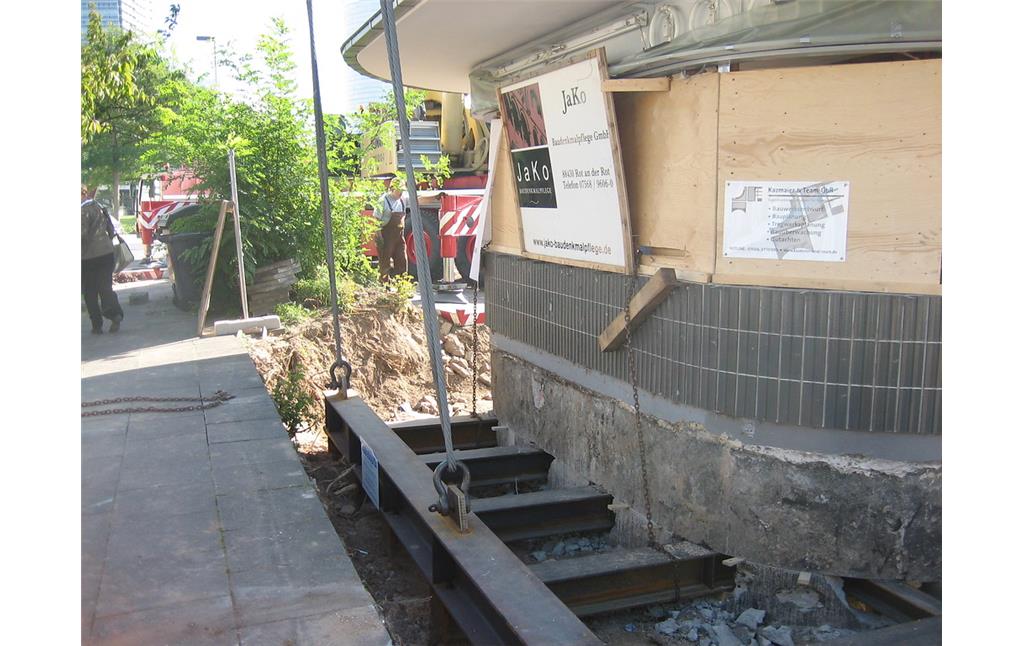 Der denkmalgeschützte Kiosk im Bonner Regierungsviertel ist vorbereitet, dass ein Kran ihn anhebt und verlädt, um diesen zu seinem Zwischenlager, einem Bauhof in Hersel, transportieren zu können (2006).