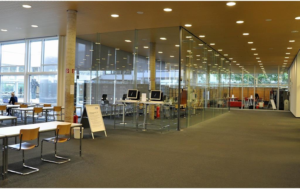 Ansicht des Lesesaals mit Blick auf den Innenhof, auf den Kopierraum und auf das Lerncafé (von links nach rechts) der Universitäts- und Landesbibliothek Bonn (2017).