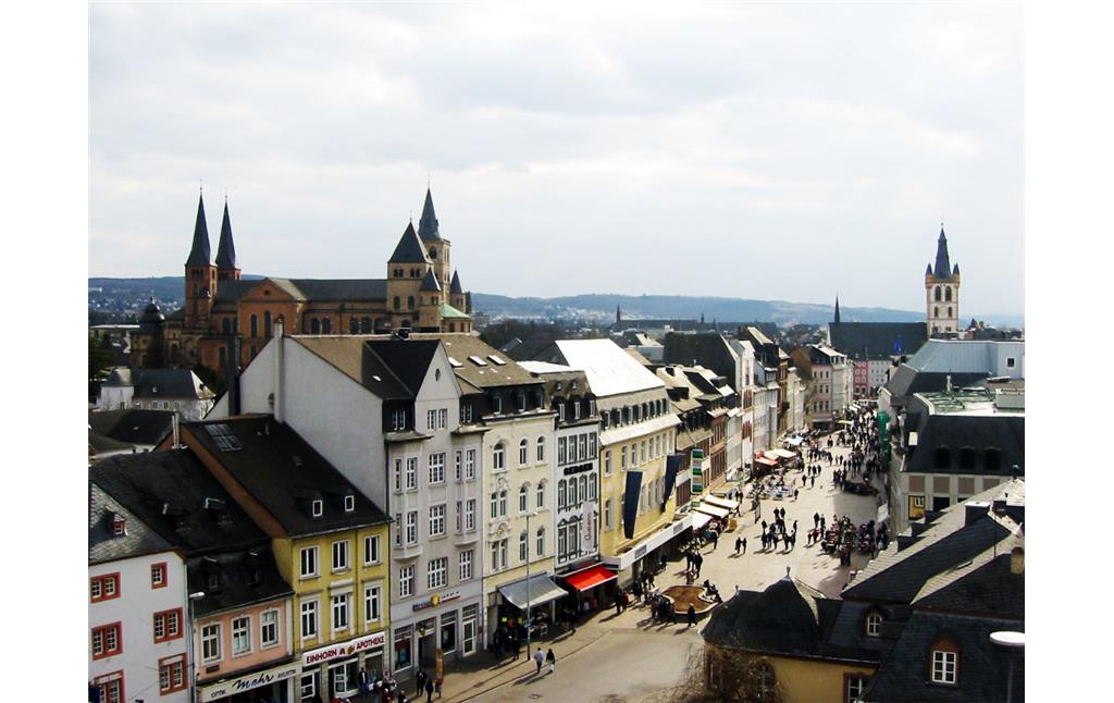 Blick über die Trierer Innenstadt von der 'Porta Nigra' aus; links der Dom und rechts hinten die Marktkirche St. Gangolf, im Vordergrund die belebte Simeonstraße (2003)