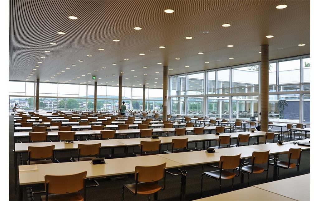 Ansicht des Lesesaals der Universitäts- und Landesbibliothek Bonn (ULB) mit vollständig verglasten Fassaden, die am rechten Rand den Blick in den Innenhof der ULB freigeben und im Hintergrund die gegenüberliegende Beueler Rheinuferseite zeigen (2017).