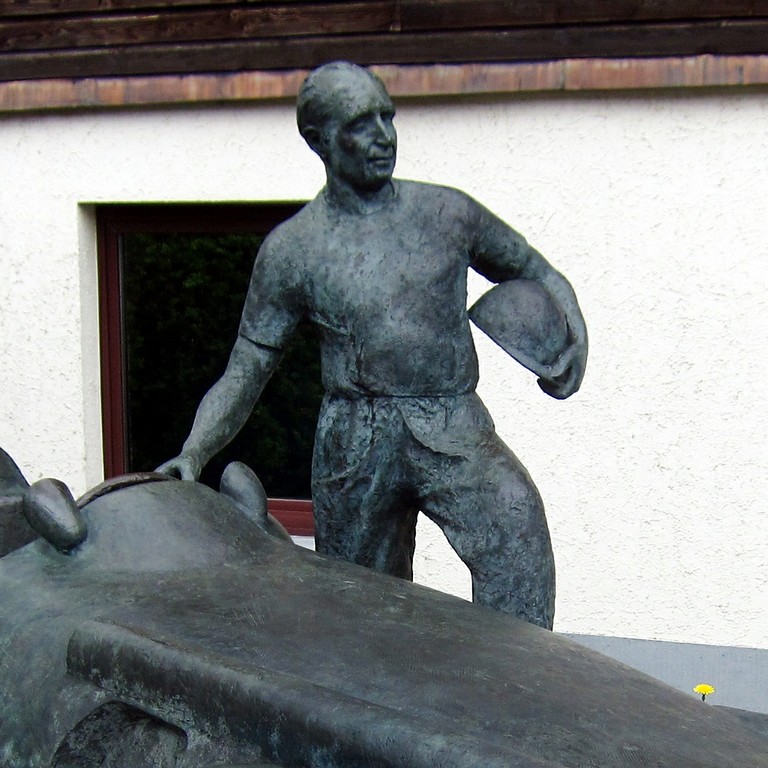 Der argentinische Automobilrennfahrer Juan Manuel Fangio (1911-1995), dargestellt als Personendenkmal an der Einfahrt zum alten Fahrerlager an der Rennstrecke Nürburgring in der Eifel (2015).