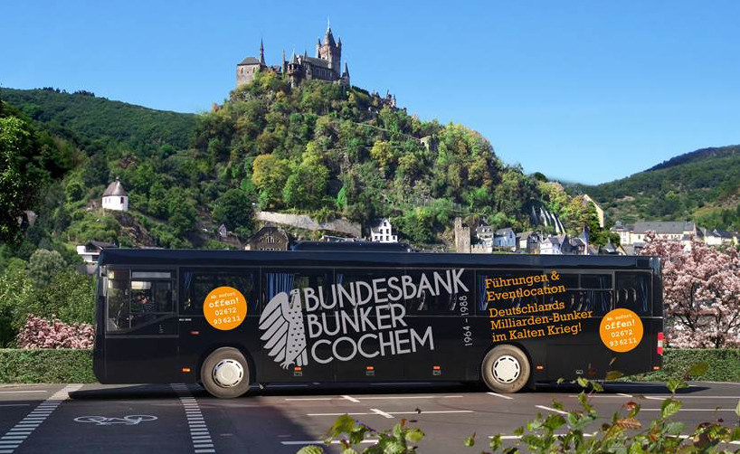 Bus des Shuttleverkehrs für Gruppenführungen im Bundesbankbunker Cochem-Cond, im Hintergrund die Cochemer Reichsburg (2015)
