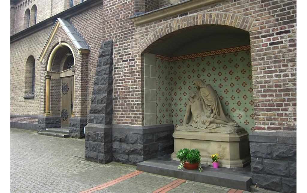 Teil der nördlichen Aussenfassade mit einer Pietà-Darstellung in einer Nische an der katholischen Pfarrkirche St. Audomar in Frechen (2013)