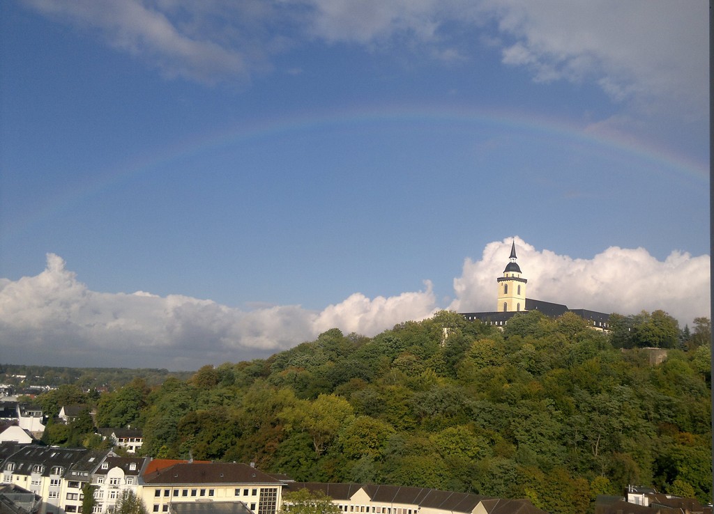 Die Abtei auf dem Michaelsberg unter einem strahlend blauem Himmel und einem Regenbogen (2010).