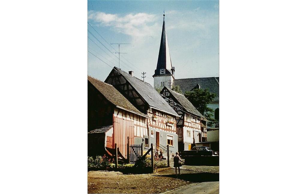 Historische Ansicht der Hauptstraße in Helferskirchen, im Hintergrund die Kirche Mariä Himmelfahrt (1970er Jahre).
