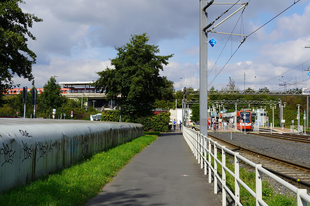 Der Verkehrsknotenpunkt für S-Bahn, Zug, Straßenbahn und Bus mit Parkplatz für PKW: Haltestelle "Weiden West" in Köln-Weiden (2021).
