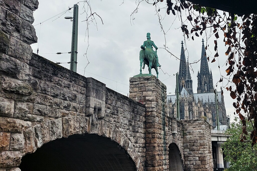 Rückwärtige Ansicht des Reiterstandbilds von Kaiser Friedrich III. an der Kölner Hohenzollernbrücke, dahinter der Dom (2021).