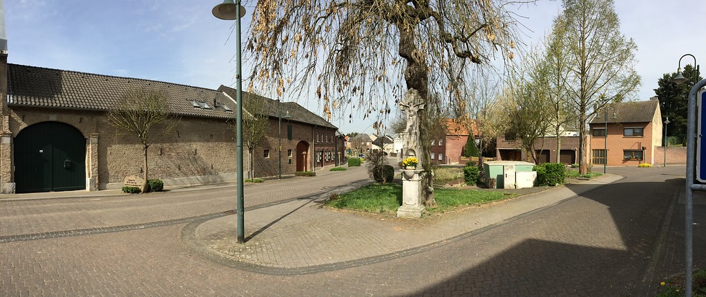 Der Dorfplatz von Titz an der Velderstraße/Bungstraße mit einem Wegekreuz am Rand einer kleinen Grünanlage (2014)