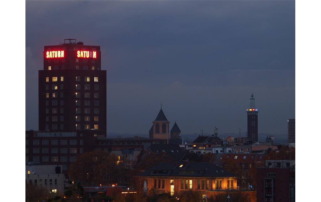 Das Hansahochhaus in Köln im Abendlicht mit Leuchtreklame (2021).