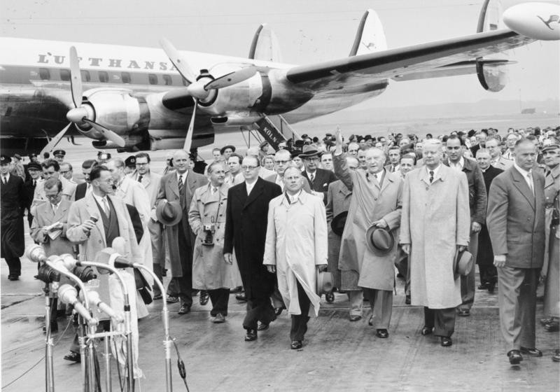 Rückkehr der Delegation um Bundeskanzler Konrad Adenauer nach der Moskau-Reise, bei der die Freilassung der letzten 9.626 deutschen Kriegsgefangenen aus dem Zweiten Weltkrieg erreicht wurde (14. September 1955 auf dem Flughafen Köln-Wahn). Im Hintergrund das viermotorige Verkehrsflugzeug "Lockheed Super Constellation" der Lufthansa (Kennung D-ALIN), mit dem die Reise durchgeführt wurde.