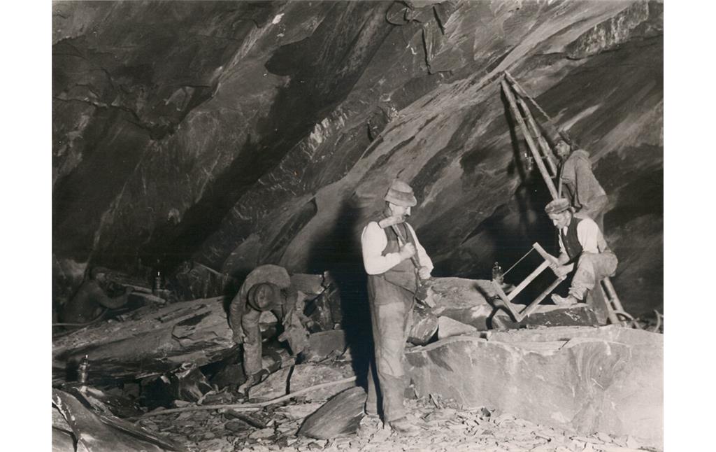 Dachschieferbergbau in Kaub: Arbeiten im Abbau wie Zerkleinern der von der Decke gefallenen Stücke in handliche Platten (1920er Jahre)