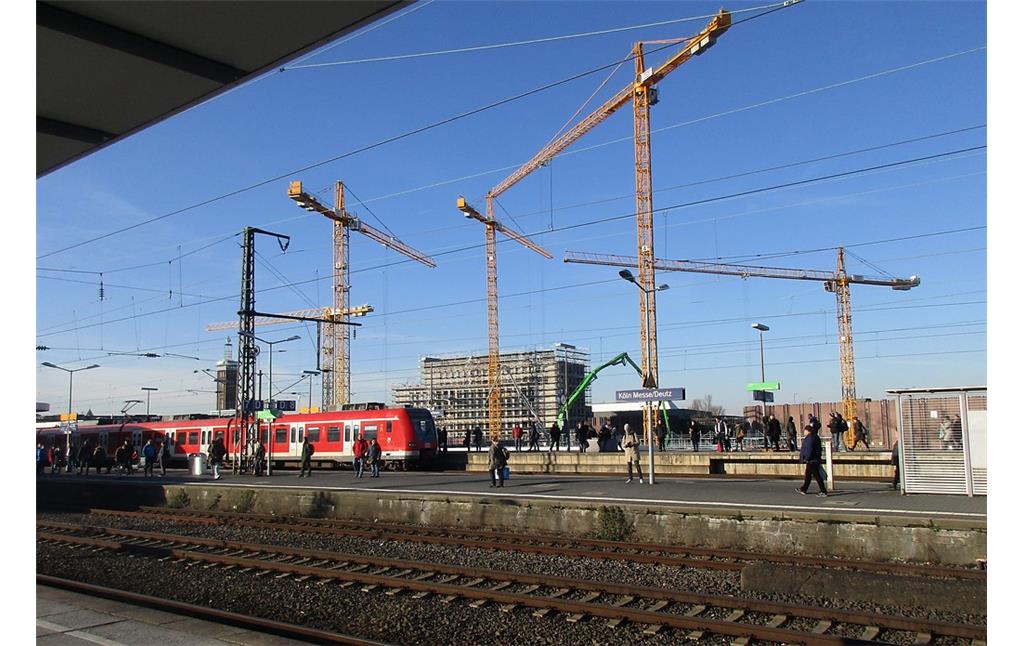 Baukräne über einer Großbaustelle der KoelnMesse in Deutz, Blick von einem Bahnsteig des Bahnhofs Köln Messe/Deutz in Richtung des Barmer Platzes (2018).