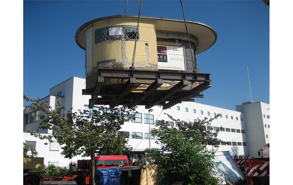Ein Kran hebt das denkmalgeschützte "Bundesbüdchen", einen Kiosk im Bonner Regierungsviertel an, um diesen zu seinem Zwischenlager, einem Bauhof in Hersel, transportieren zu können (2006).