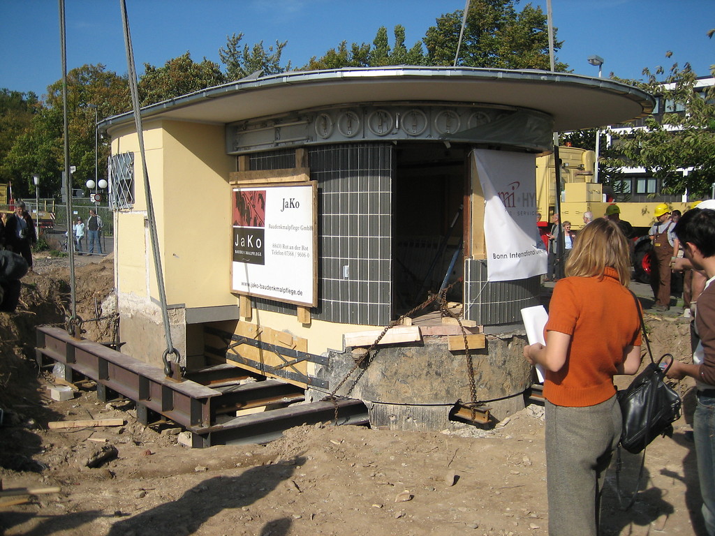 Der denkmalgeschützte Kiosk im Bonner Regierungsviertel ist vorbereitet, dass ein Kran ihn anhebt und verlädt, um diesen zu seinem Zwischenlager, einem Bauhof in Hersel, transportieren zu können (2006).