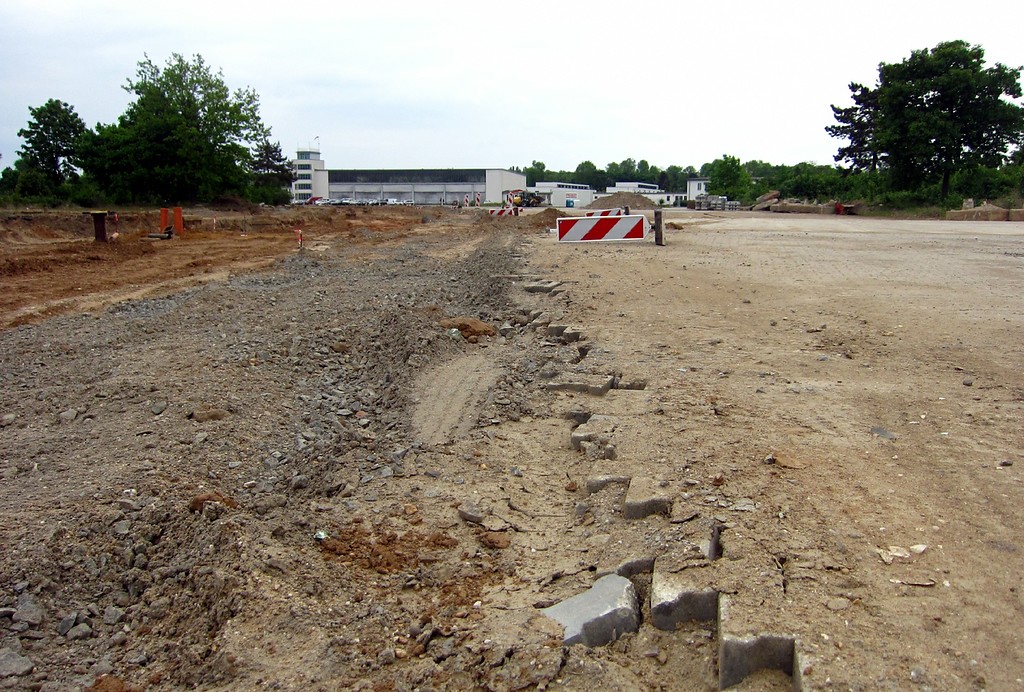 Bauarbeiten auf dem früheren Rollfeld des Flughafens Butzweilerhof in Köln-Ossendorf, im Hintergrund die Flugzeughalle I mit dem Tower (2015).