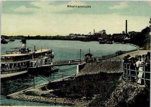 Ansichtskarte des Porzer Rheinufers von 1911 mit der Bootsanlagestelle, heute Köln-Düsseldorfer, und der Rampe. Im Hintergrund sind weitere Schiffsanlegestellen und Industrieanlagen zu erkennen.