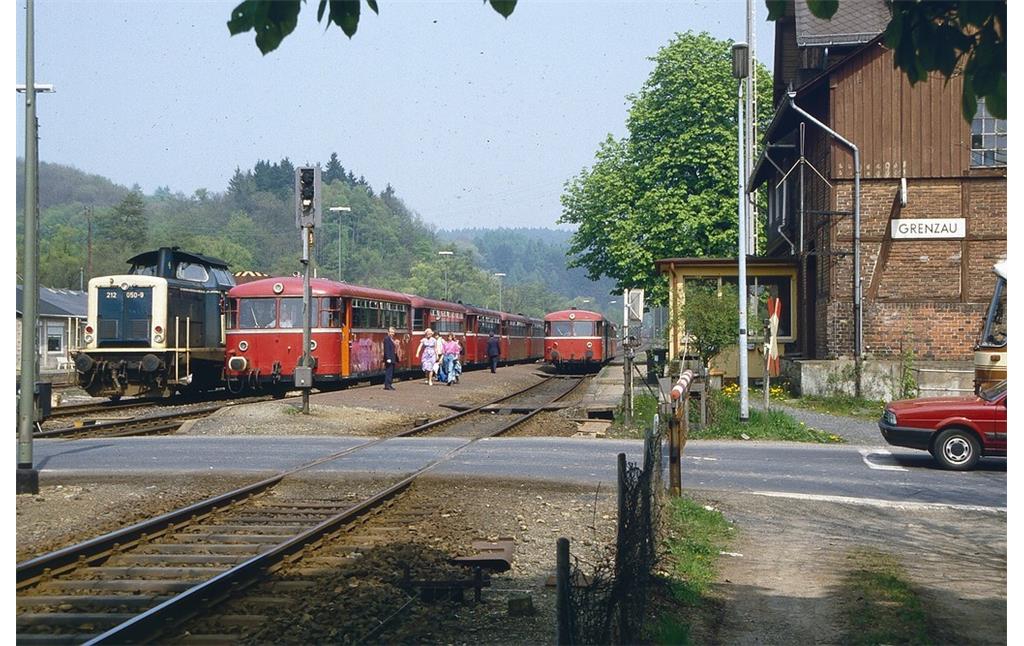 Der Bahnhof Grenzau im Westerwaldkreis an der Brexbachtalbahn in den 1980er Jahren, in der Bildmitte zwei "Uerdinger Schienenbusse" und links eine dieselhydraulische Lokomotive Baureihe V 100, Typ 212, der Deutschen Bundesbahn.