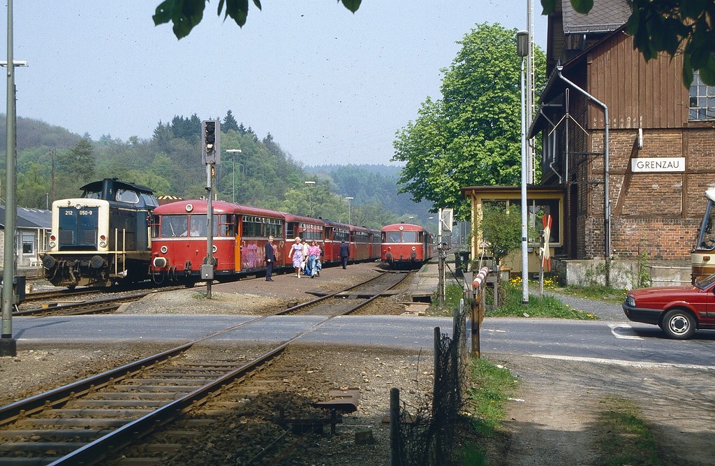 Der Bahnhof Grenzau im Westerwaldkreis an der Brexbachtalbahn in den 1980er Jahren, in der Bildmitte zwei "Uerdinger Schienenbusse" und links eine dieselhydraulische Lokomotive Baureihe V 100, Typ 212, der Deutschen Bundesbahn.