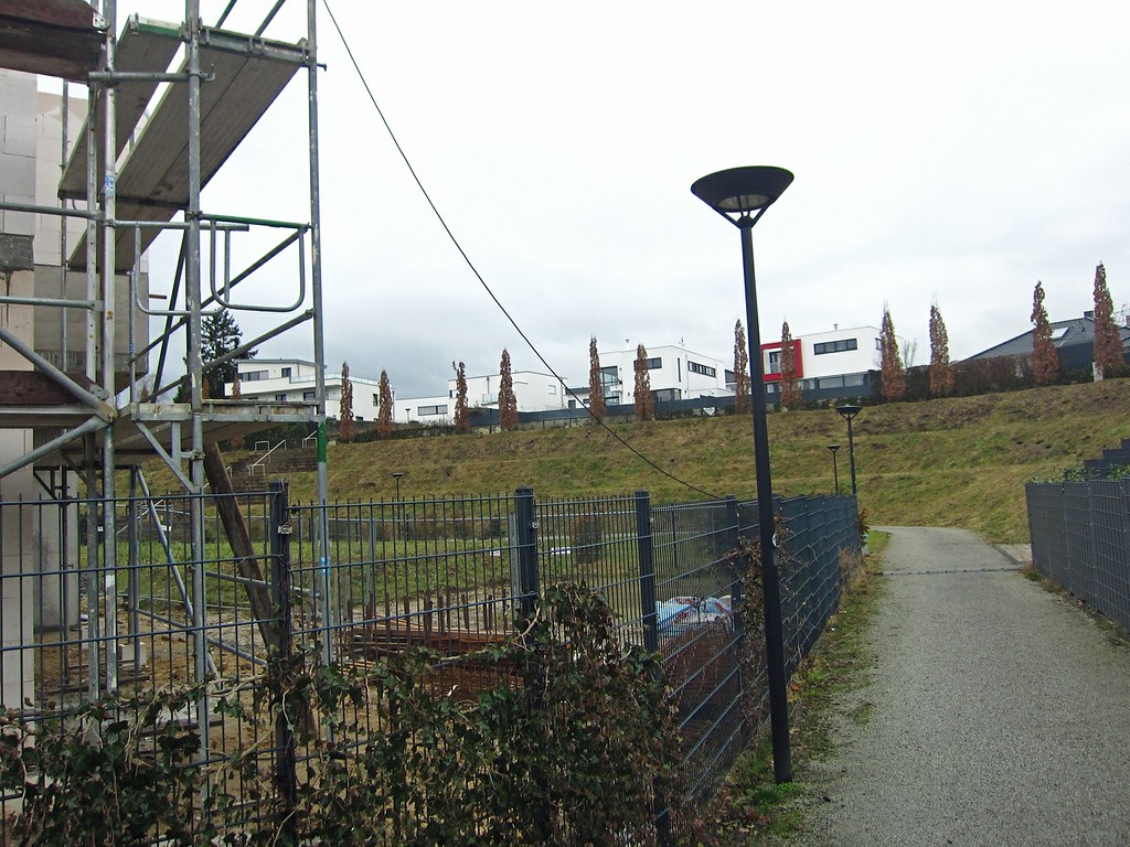 Schmaler Pfad zwischen der erhaltenen Nordterrasse und der neuen Wohnanlage mit Blick auf die Terrasse der früheren Haupttribüne des ehemaligen Bökelbergstadions (2015).