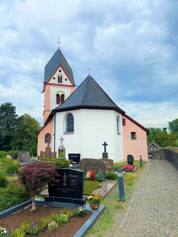 Die katholische Kirche St. Michael in Köln-Zündorf, Blick auf die Ostseite mit dem polygonalen Chor (2023). Im Vordergrund liegt der Friedhof von Niederzündorf.