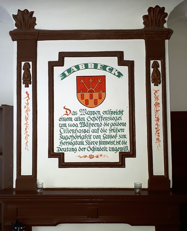Tafel über einem Kamin im Forsthaus Hasenacker in Sonsbeck-Labbeck mit Erläuterungen zum Wappen von Labbeck (2018)
