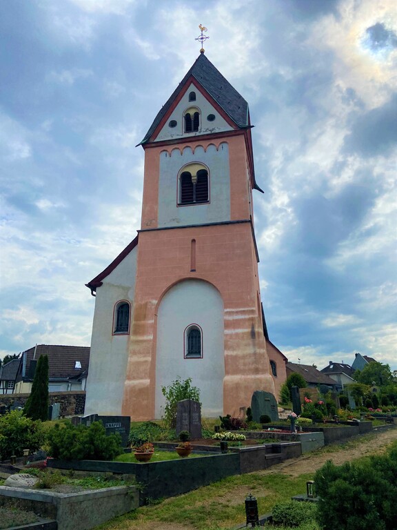 Die katholische Kirche St. Michael in Köln-Zündorf, Blick in Richtung Norden (2023).Die katholische Kirche St. Michael in Köln-Zündorf, Blick auf den Westturm (2023). Im Vordergrund liegt der Friedhof von Niederzündorf.
