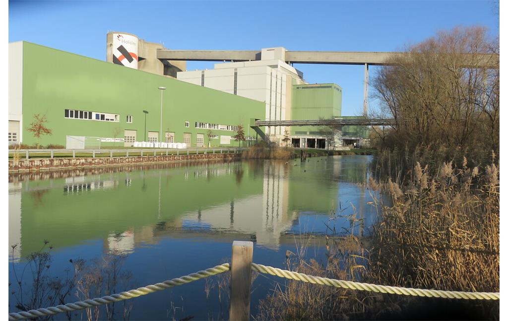 In östlicher Richtung verlaufen die Reste des Breitenburger Schiffahrtskanals entlang der Verladeeinrichtungen für den Zementversand des Werkes Lägerdorf von der Holcim (Deutschland) GmbH (2019).