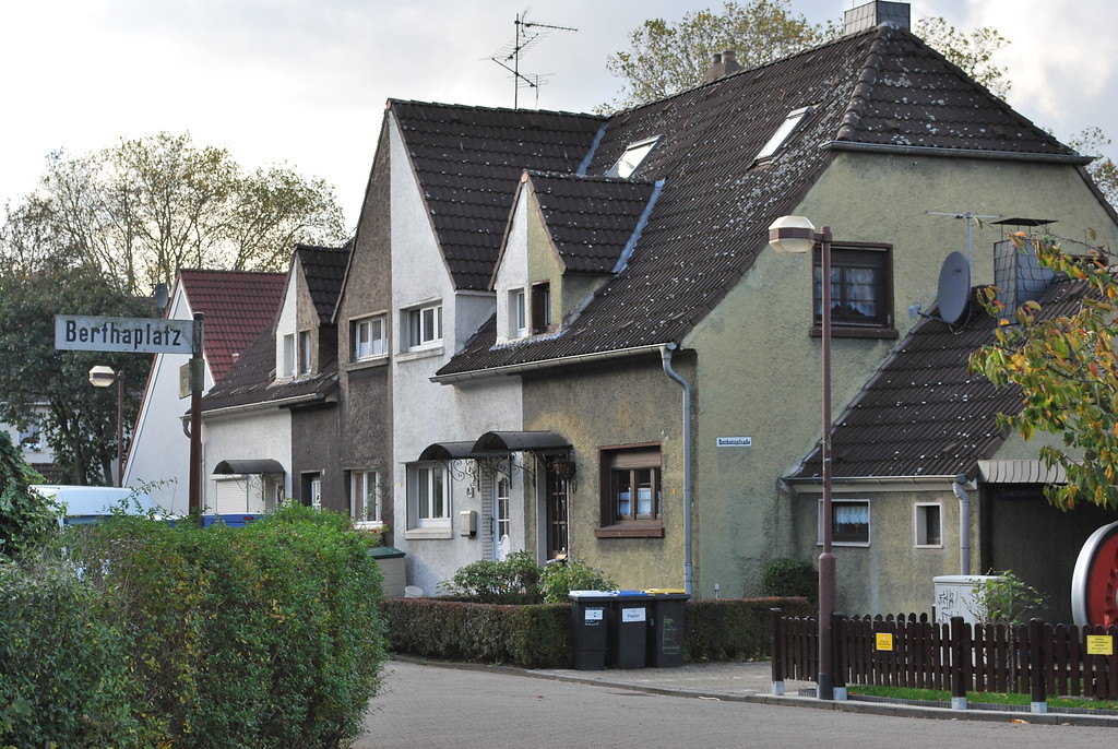 Ausschnitt der Siedlung Margarethenhof in Duisburg-Rheinhausen am Berthaplatz (2013). Zu erkennen sind in Reihe gebaute, giebelständige Einfamilienhäuser mit verbindendem ehemaligem Wirtschaftstrakt (rechts). Gärten vor und hinter dem Haus unterstreichen den ländlichen Charakter