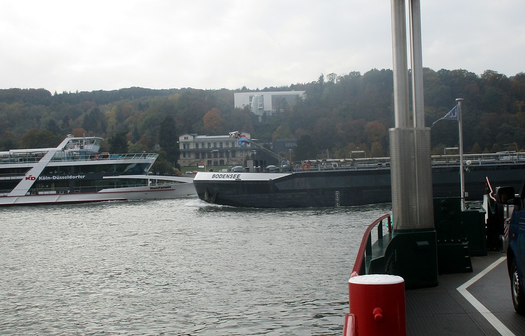 Die Rheinfähre "Siebengebirge" auf ihrer Fahrt von Bad Honnef-Lohfeld nach Remagen-Rolandseck (2016). Ein Passagierschiff und ein Frachtschiff queren gleichzeitig den Fährweg.