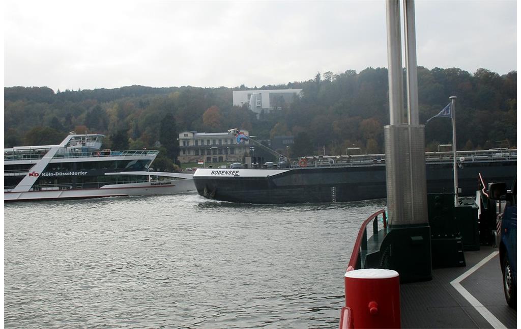 Die Rheinfähre "Siebengebirge" auf ihrer Fahrt von Bad Honnef-Lohfeld nach Remagen-Rolandseck (2016). Ein Passagierschiff und ein Frachtschiff queren gleichzeitig den Fährweg.