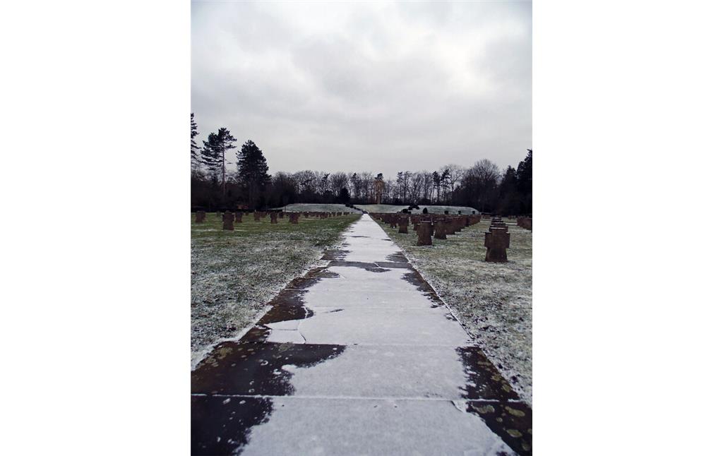 Ein verschneiter Weg auf dem Gräberfeld für deutsche Kriegsopfer auf dem Westfriedhof in Köln-Vogelsang (2021).