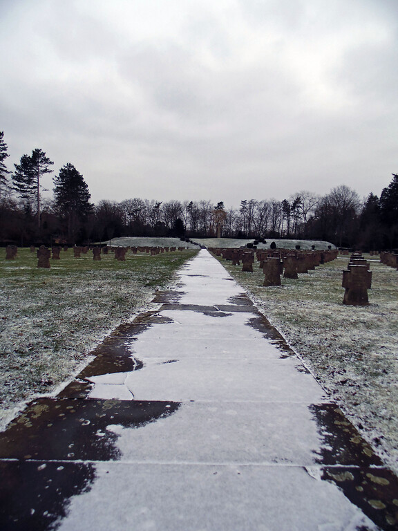 Ein verschneiter Weg auf dem Gräberfeld für deutsche Kriegsopfer auf dem Westfriedhof in Köln-Vogelsang (2021).
