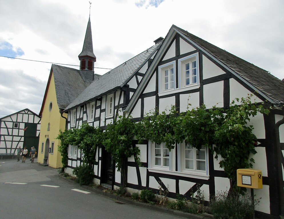 Fachwerkhäuser und dahinter die Kapelle Sankt Josef auf der sogenannten "Linzer Terrasse" oberhalb von Erpel gelegenen Ortsteil Orsberg (2020).