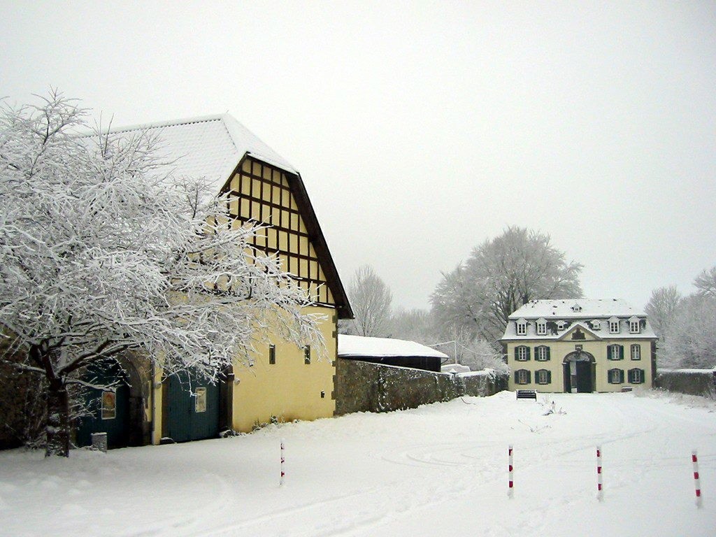 Die Zehntscheune der Zisterzienserabtei Heisterbach (links) und im Hintergrund das barocke Torhaus im Schnee (2010).