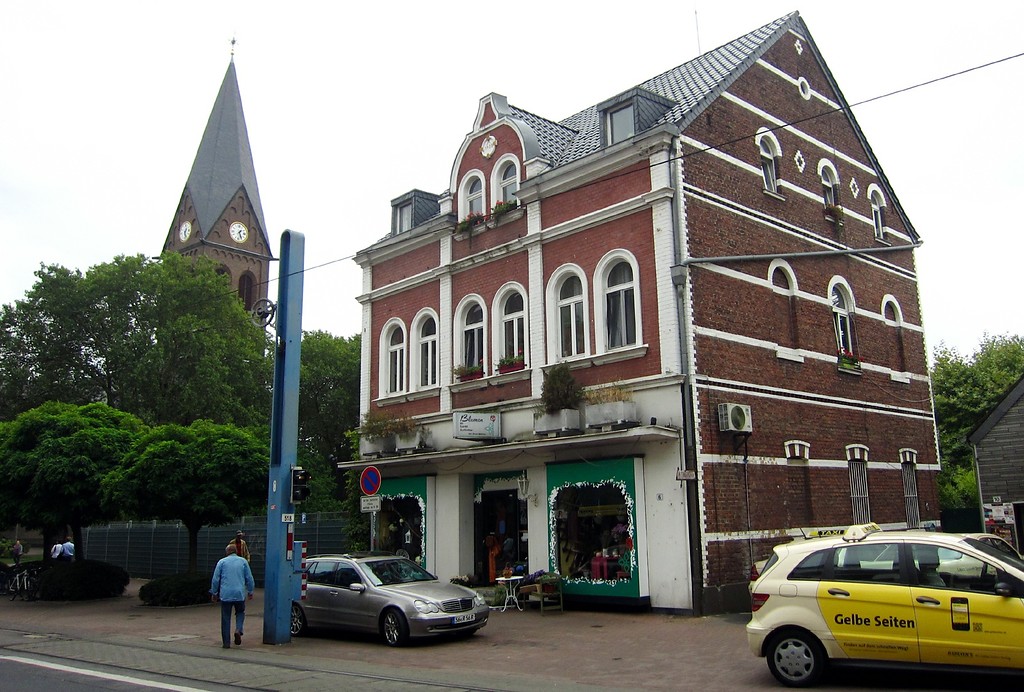 Turm der Pfarrkirche St. Audomar in Frechen und ein Geschäftshaus in der Hauptstraße (2013)