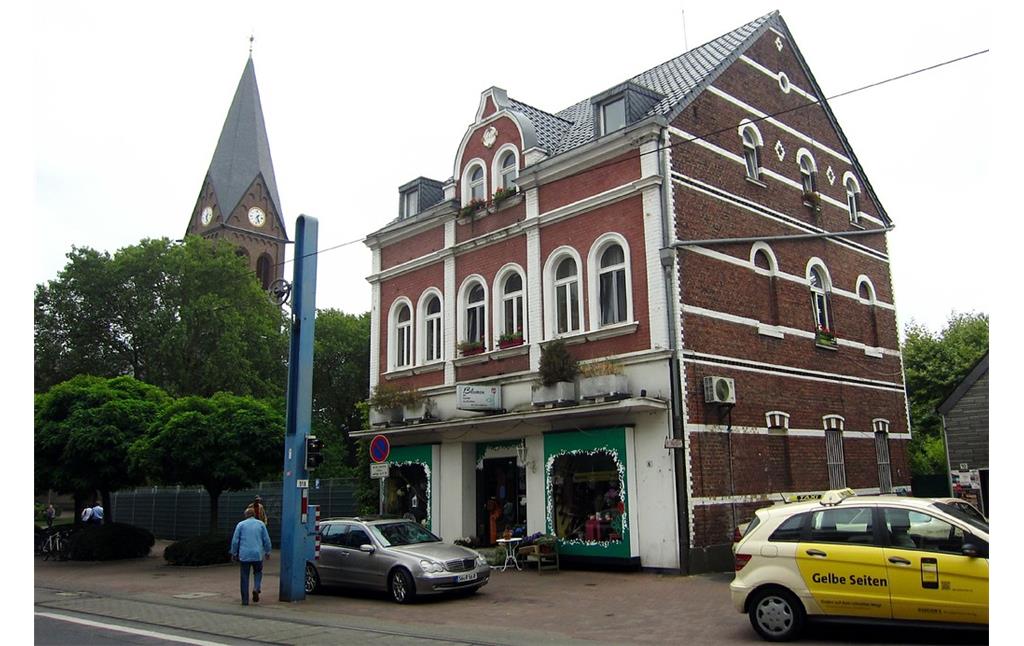 Turm der Pfarrkirche St. Audomar in Frechen und ein Geschäftshaus in der Hauptstraße (2013)