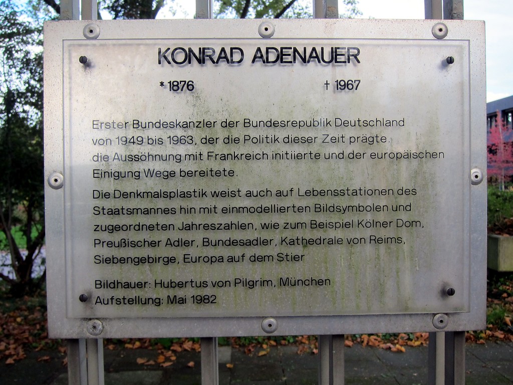 Hinweisschild auf den Adenauerkopf, den Porträtkopf des ersten Bundeskanzlers, Konrad Adenauer, geschaffen 1981/82 von Hubertus von Pilgrim, am Bundeskanzlerplatz vor dem ehemaligen Bundeskanzleramt in Bonn (2014).