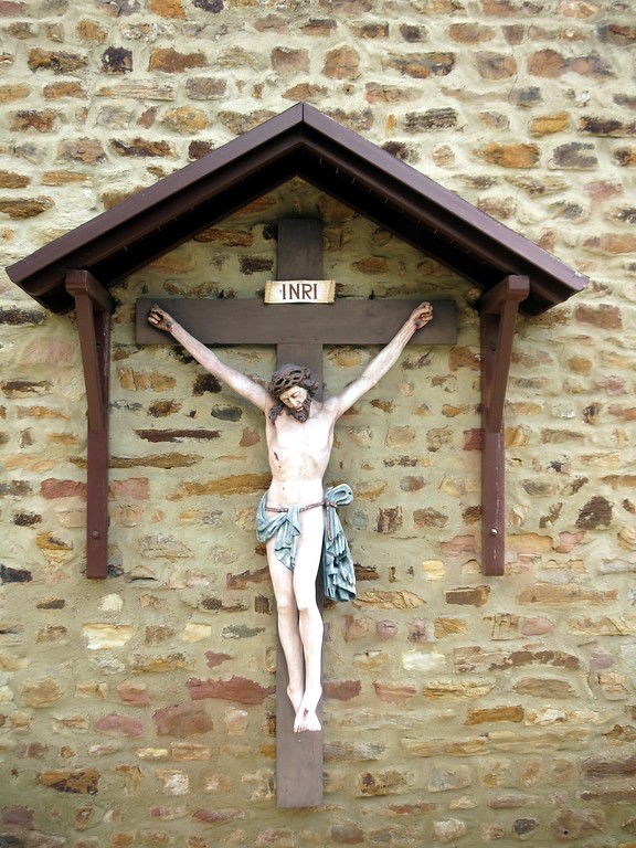 Kreuzigungsfigur am Mauerwerk der katholischen Pfarrkirche "St. Johannes Enthauptung" in Koblenz-Metternich (2014).