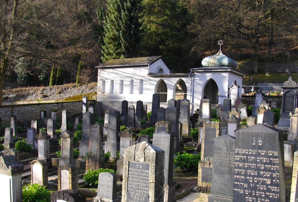 Teilansicht des jüdischen Friedhofs in Bad Ems mit der Friedhofshalle von 1929 im Hintergrund (2008).